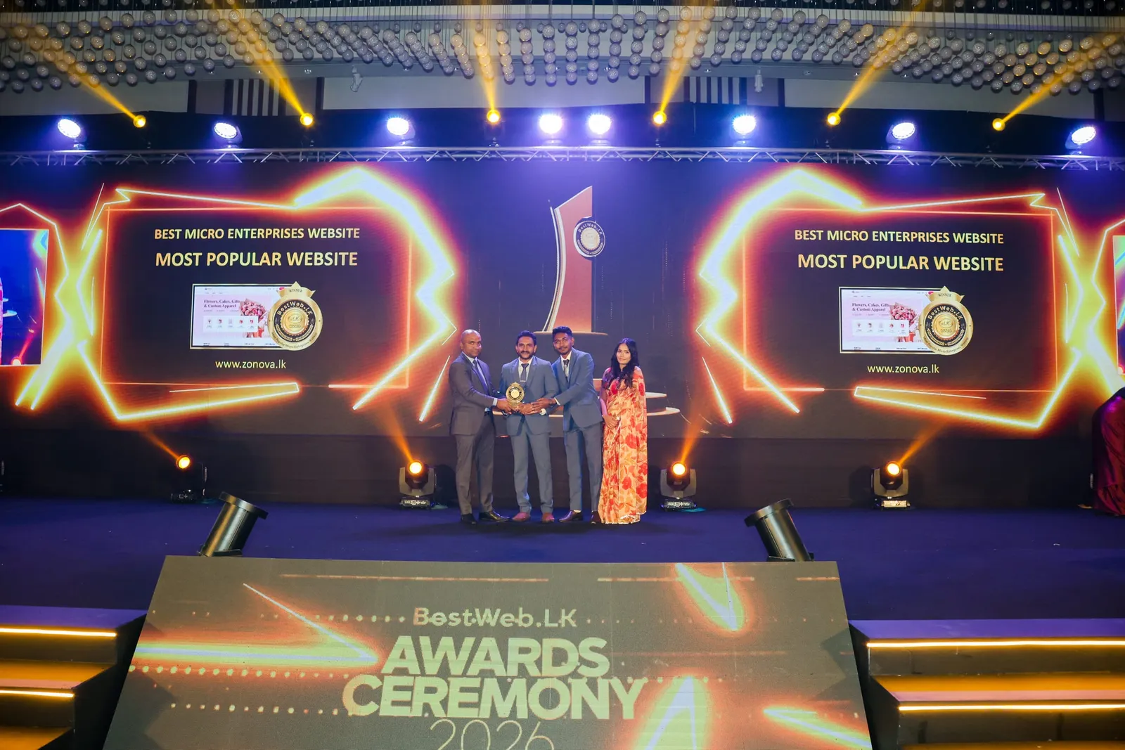The Zonova team on stage as the ceremony screens announce Best Micro Enterprises Website, Most Popular Website, beside a screenshot of zonova.lk.